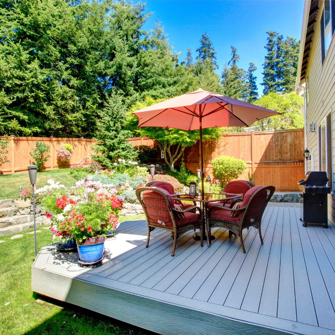 Backyard with a deck, flowers and a well-kept lawn