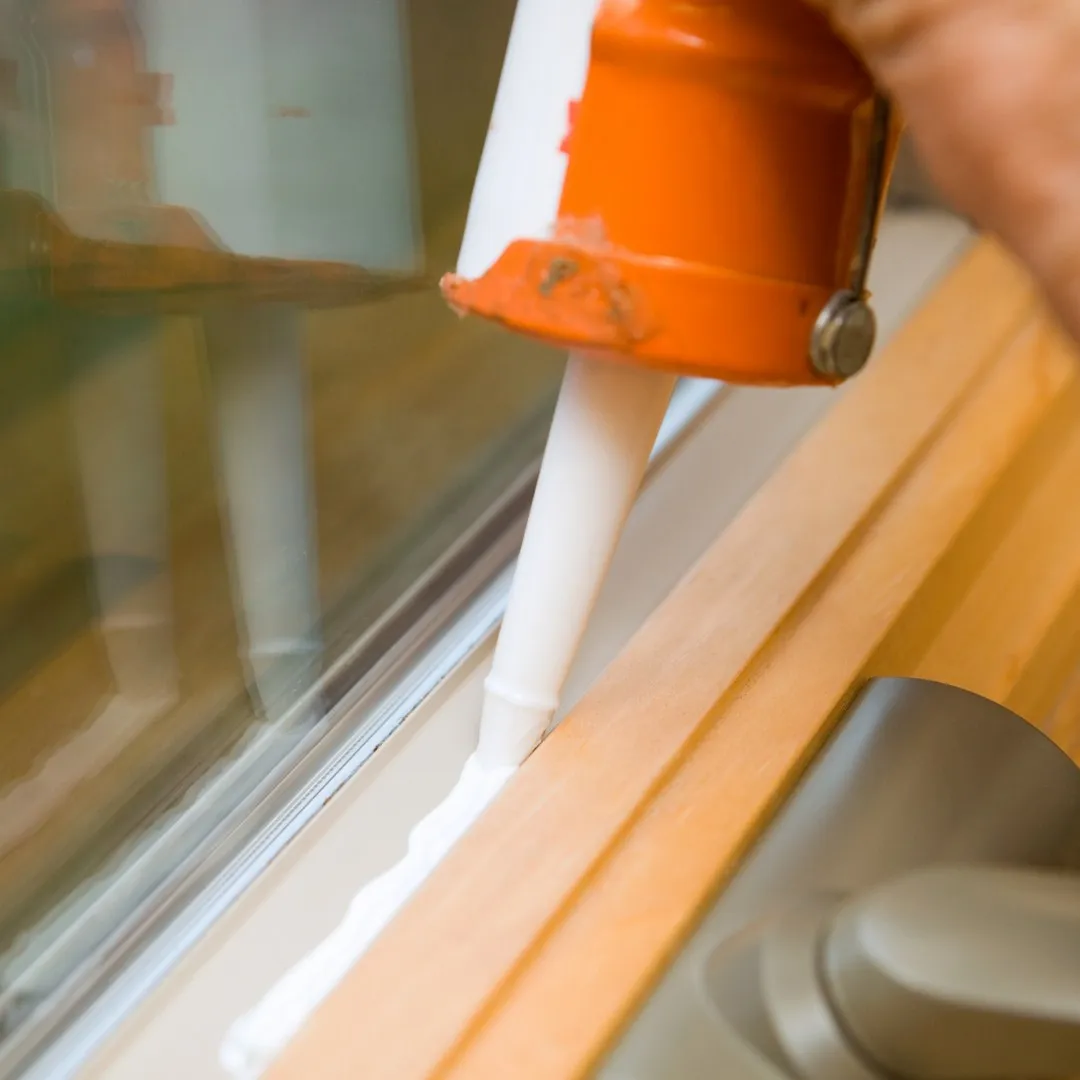 Sealing a window frame with a caulk gun