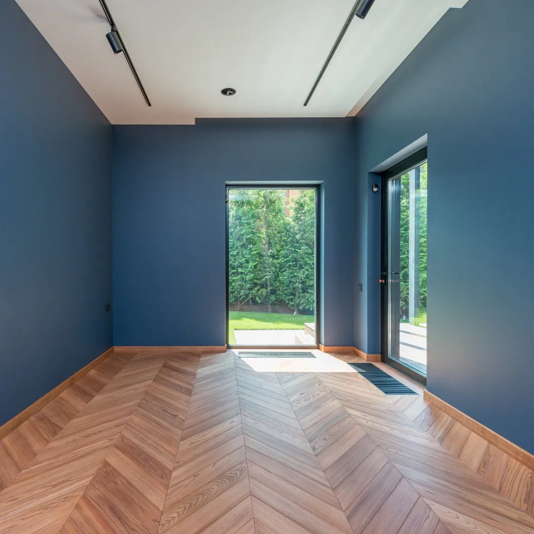 Empty room with freshly painted blue walls and wood floor