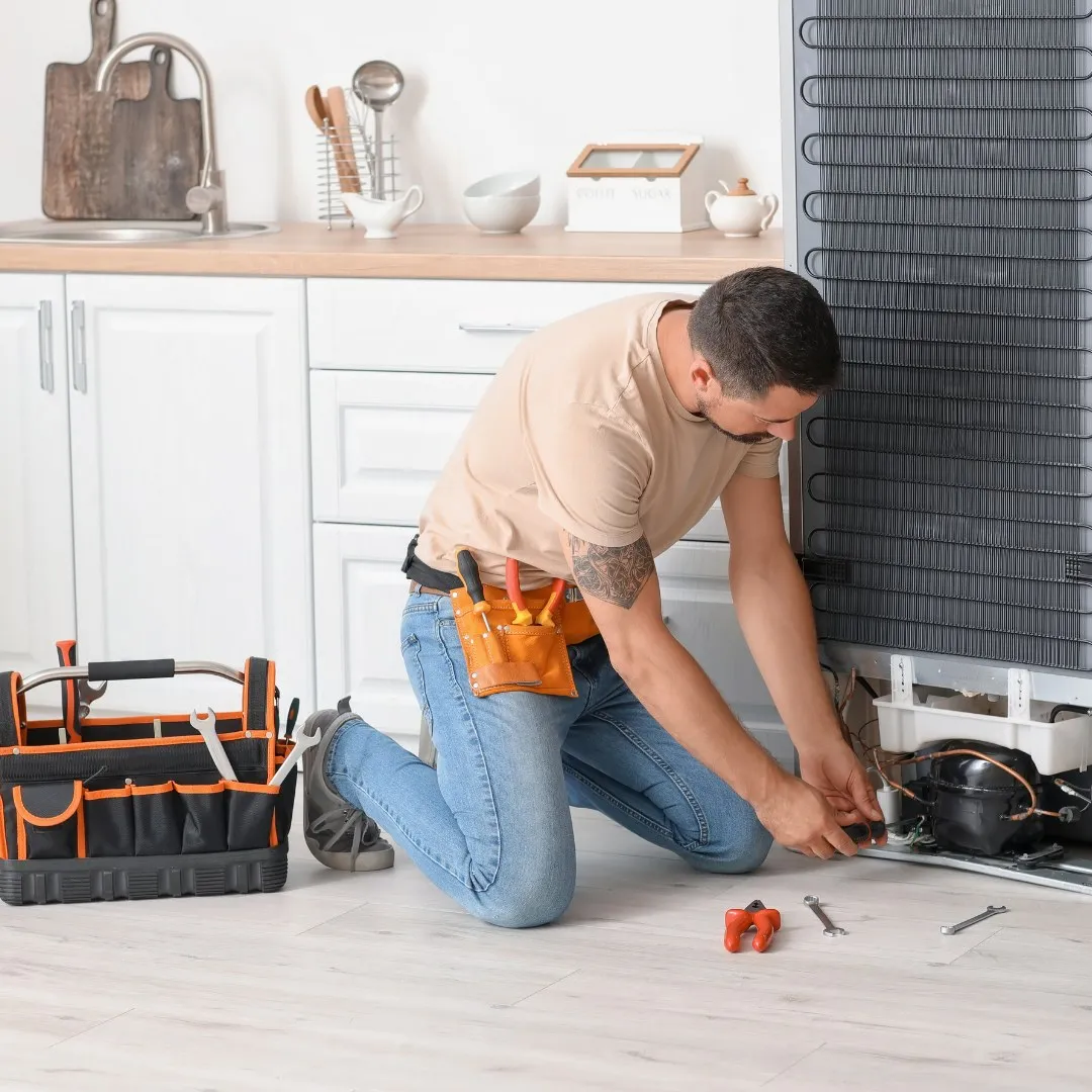 Handyman kneeling to make a kitchen repair