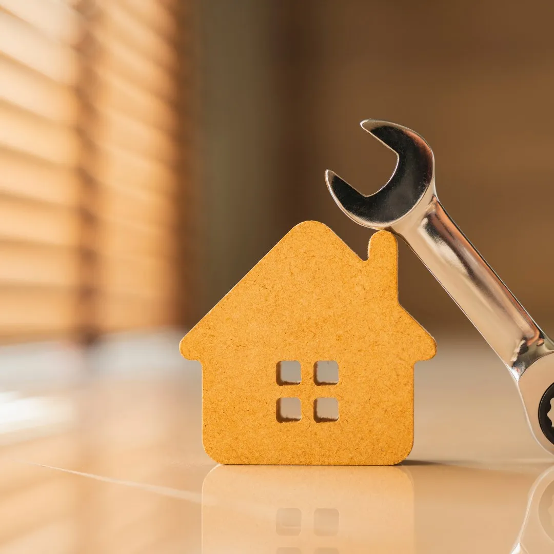 Small house model next to a wrench