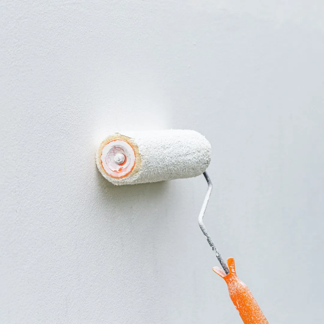 Paint roller on a smooth white wall