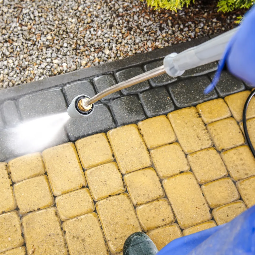 Pressure washer nozzle cleaning paver stones